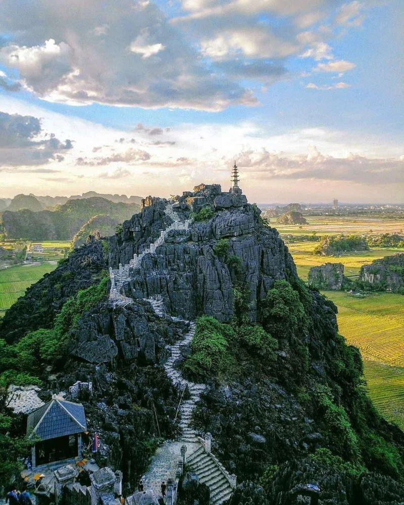 Bậc thang đá ngoằn ngoèo lên đỉnh núi đá vôi có ngôi chùa nhỏ tại Hang Múa, nhìn xuống cánh đồng lúa ở Ninh Bình.