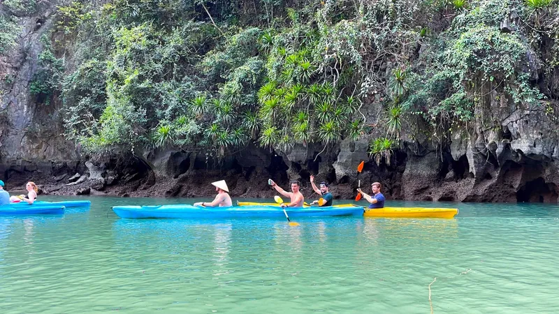 Du khách chèo kayak qua vách đá vôi và làn nước xanh ở vịnh Lan Hạ gần Cát Bà